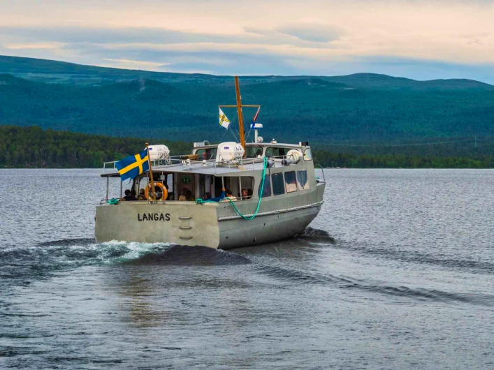Boat crossing a mountain lake in northern Sweden.