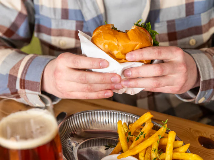 A person holding a hamburger at Abisko Turiststation.
