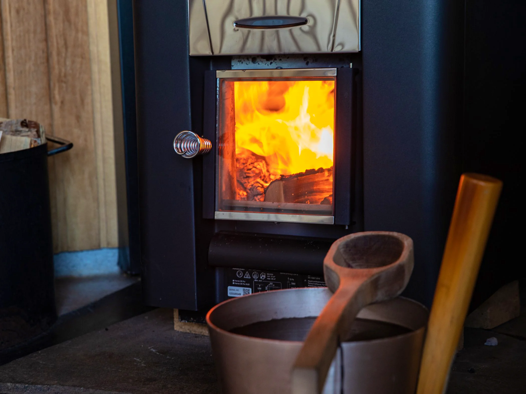 Wood-fired sauna with a fire burning in the stove.