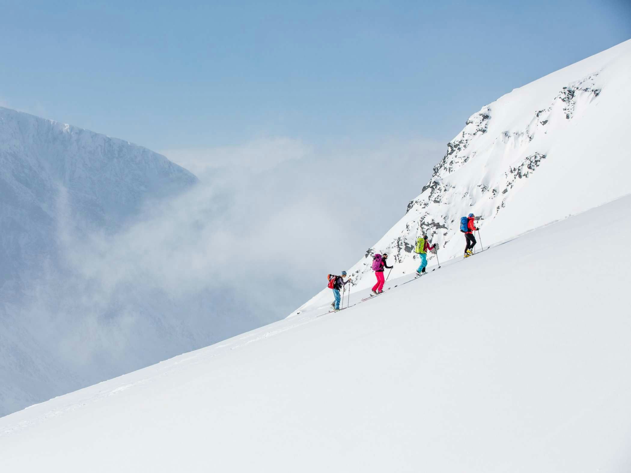 Ski tourers ascending a snow-covered slope in the Kebnekaise mountains, Swedish Lapland.