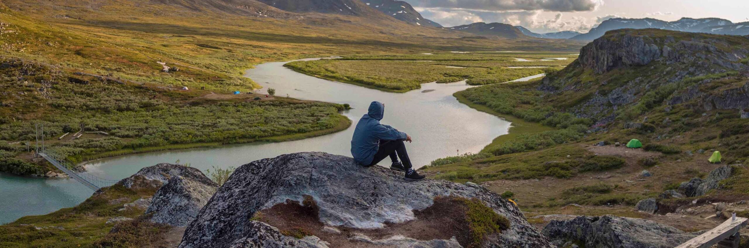 Man sitting on a stone along Kungsleden trail