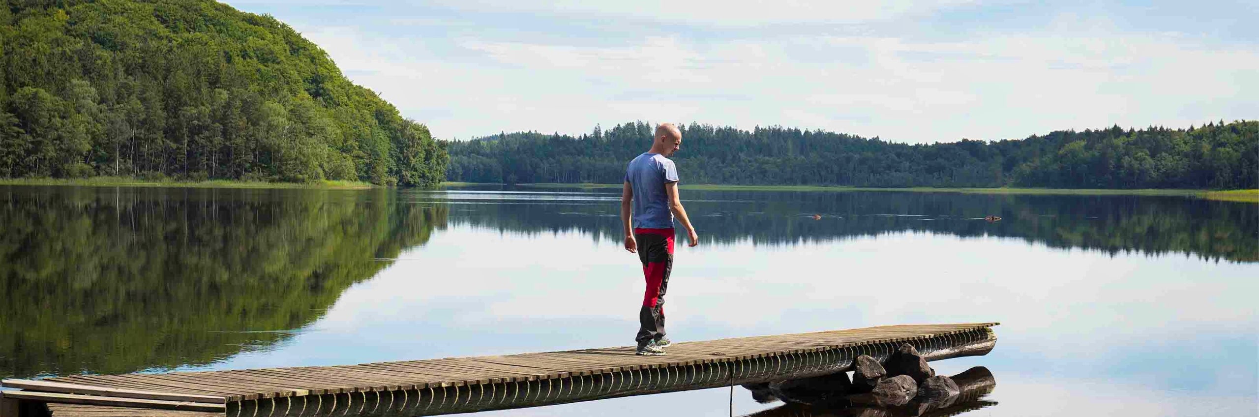 Man på en brygga med en sjö i bakgrunden