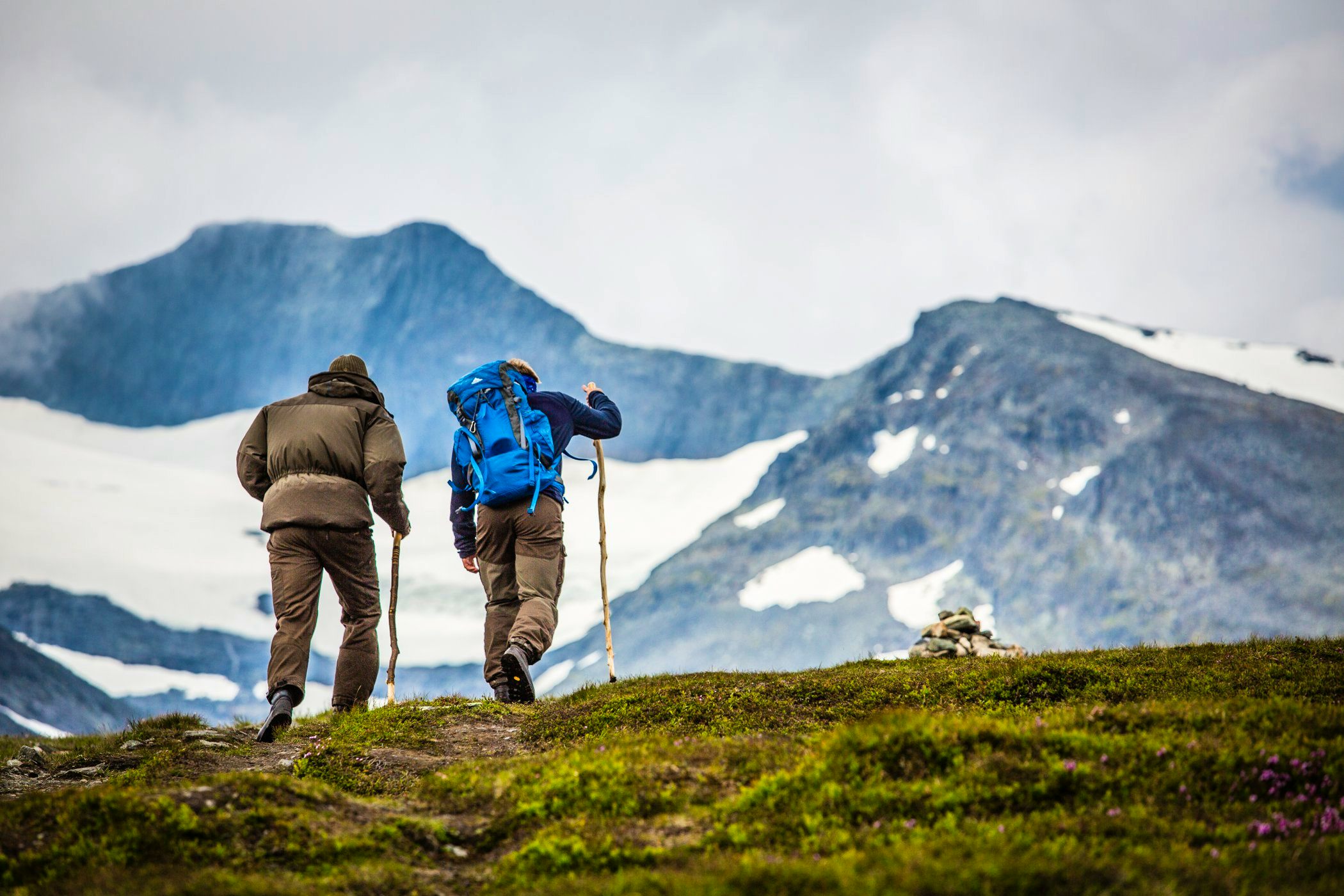 Two hikers walking towards the mountain.