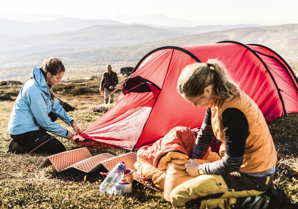 Three people camping in the mountains.