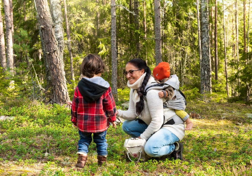 A woman and two children in the woods.