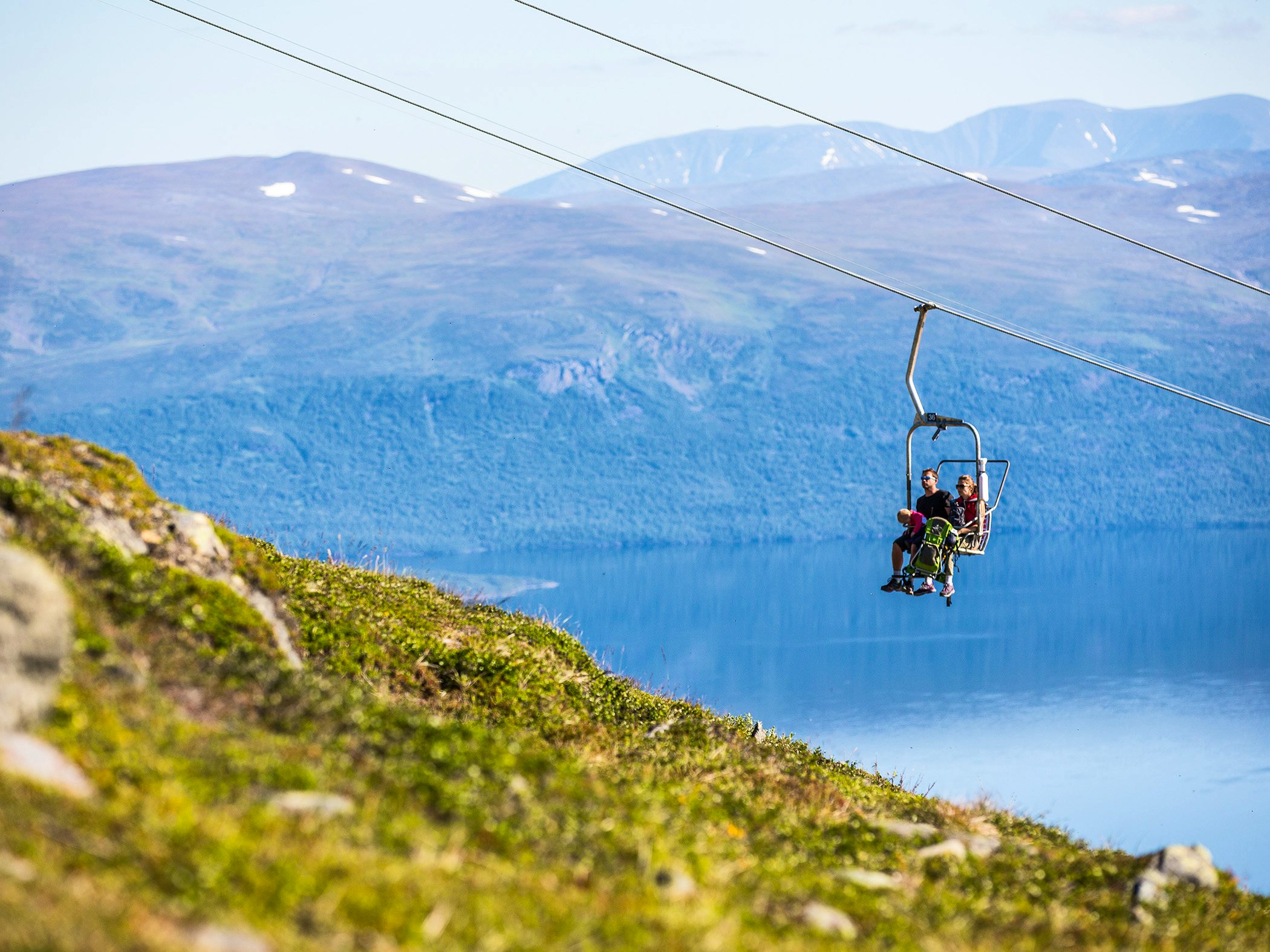 Two persons going up to mount Nuolja in the cable lift.