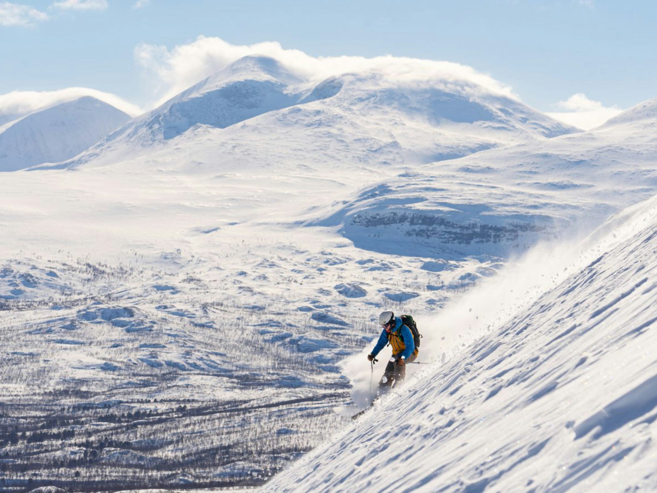 A person skiing down a steep slope in Abisko.