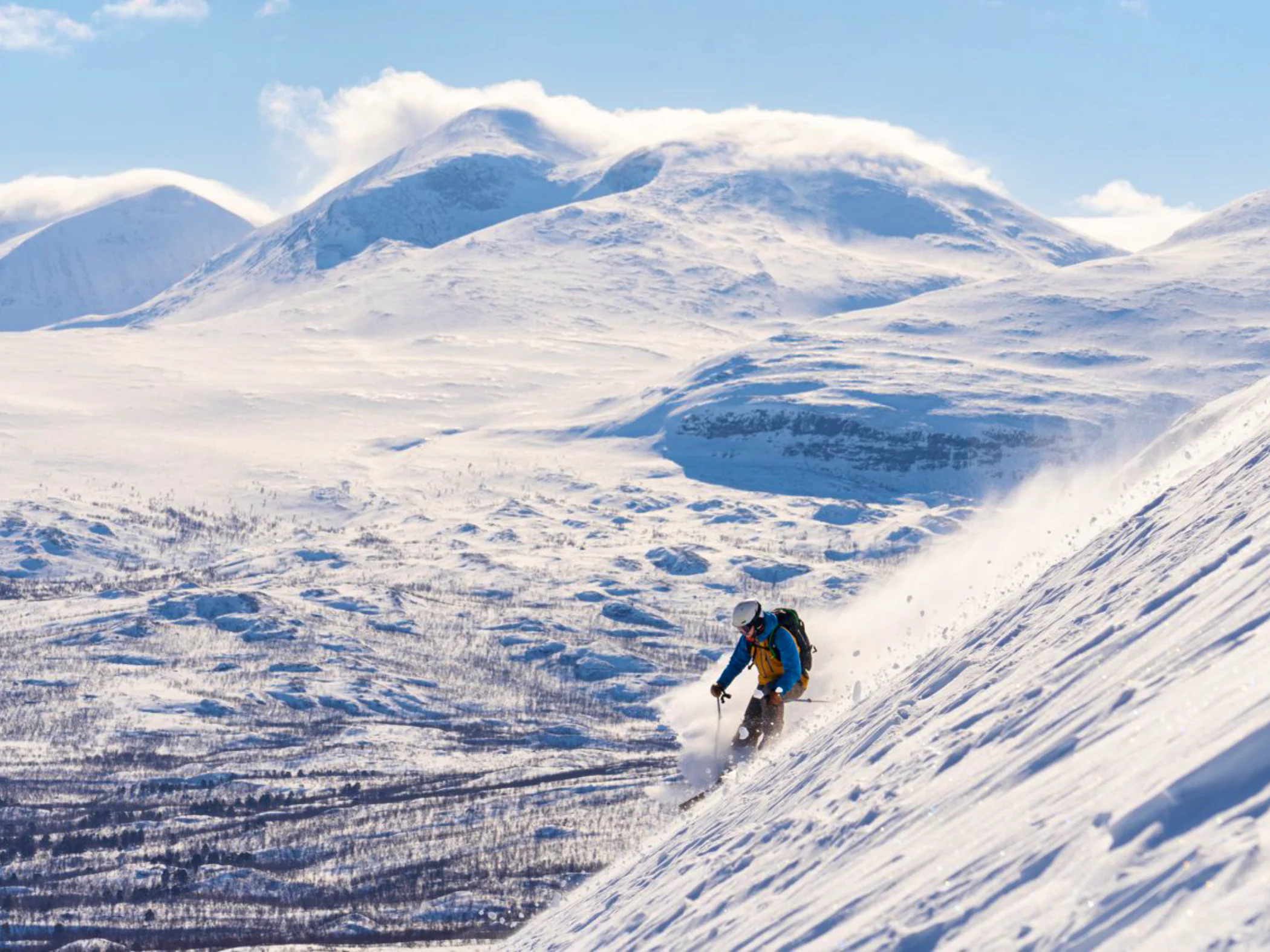 A person skiing down a steep slope in Abisko.