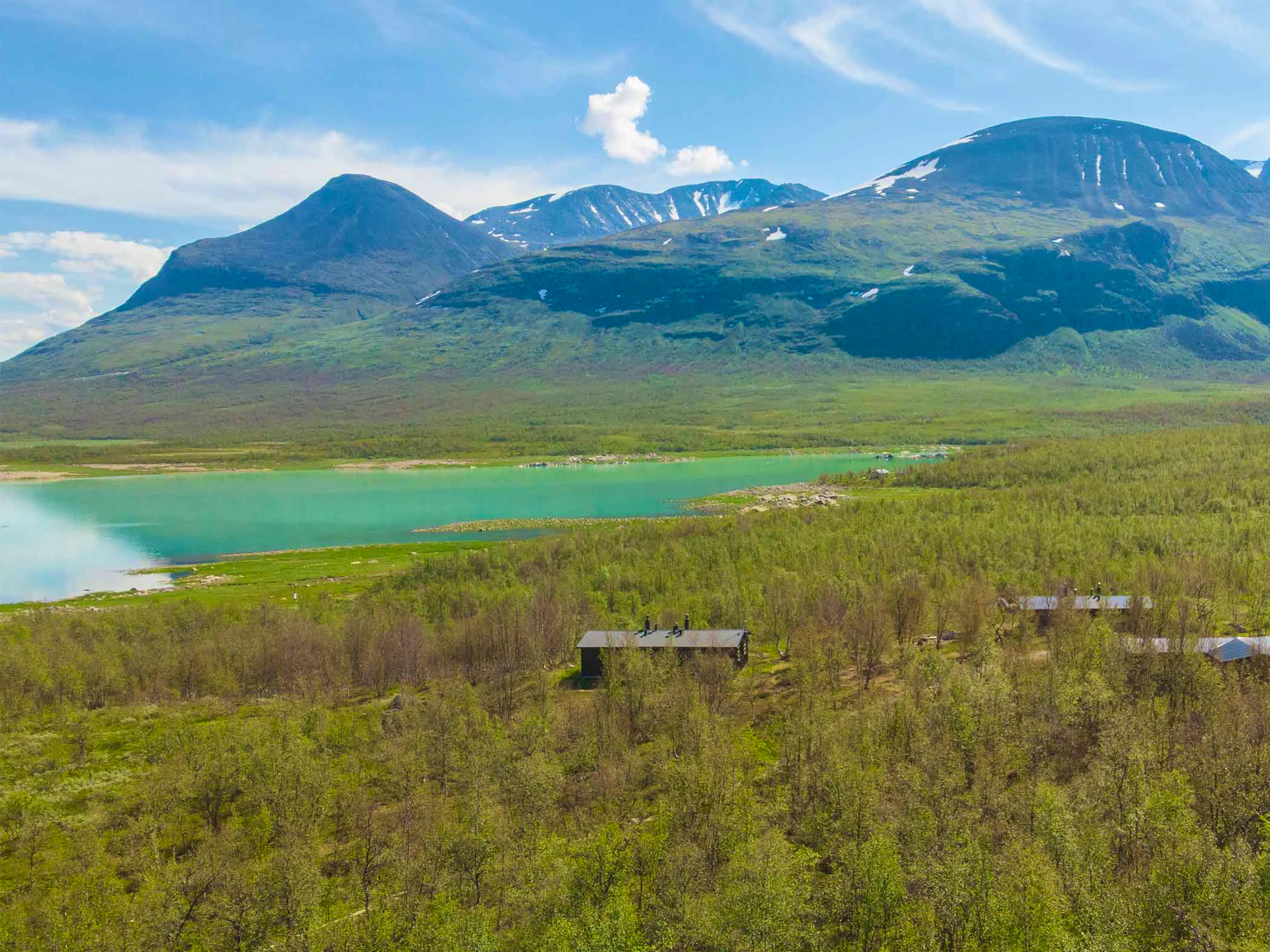 Cabin near a lake and mountains.