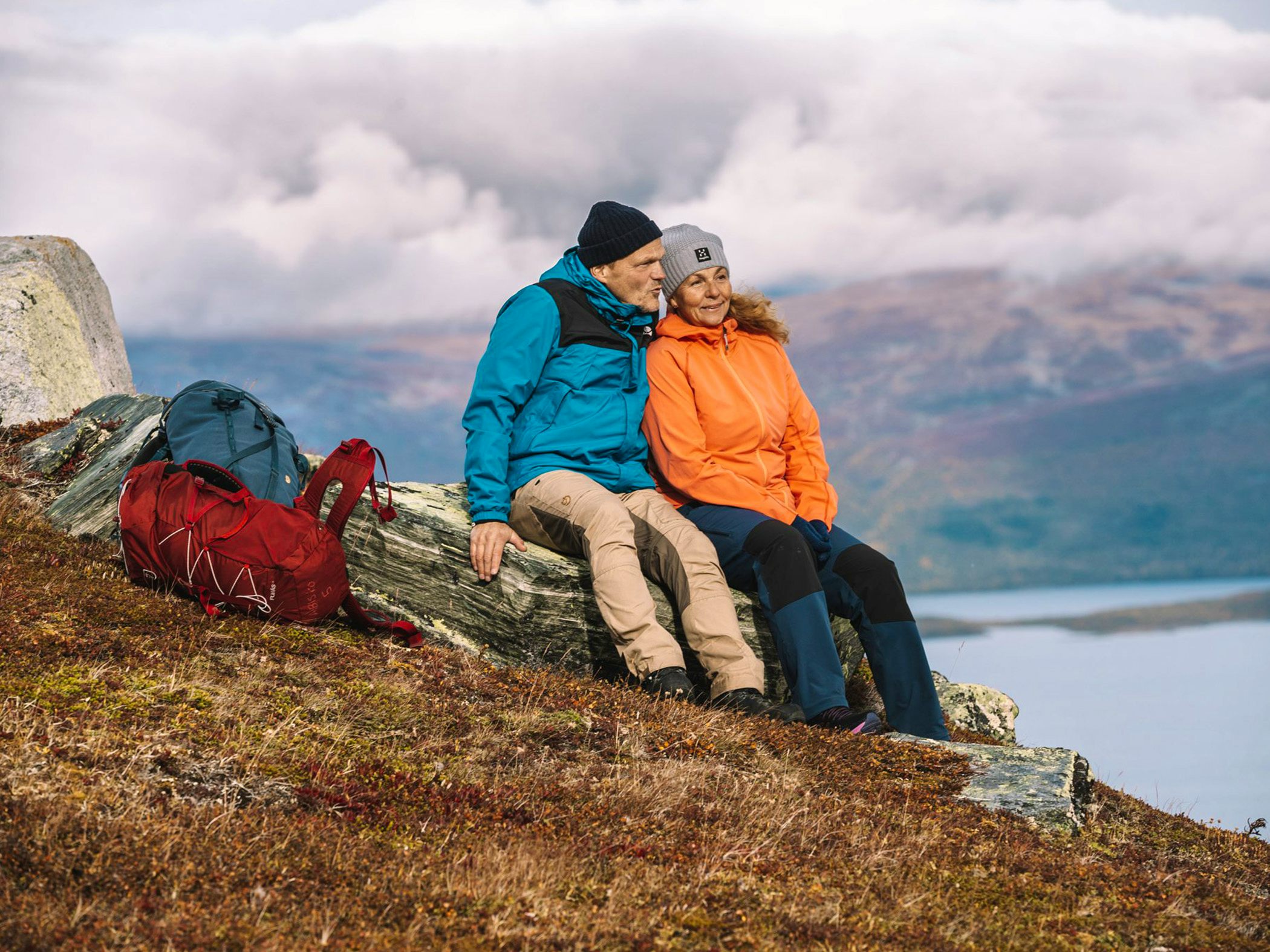 Couple sitting on a stone in the mountains.