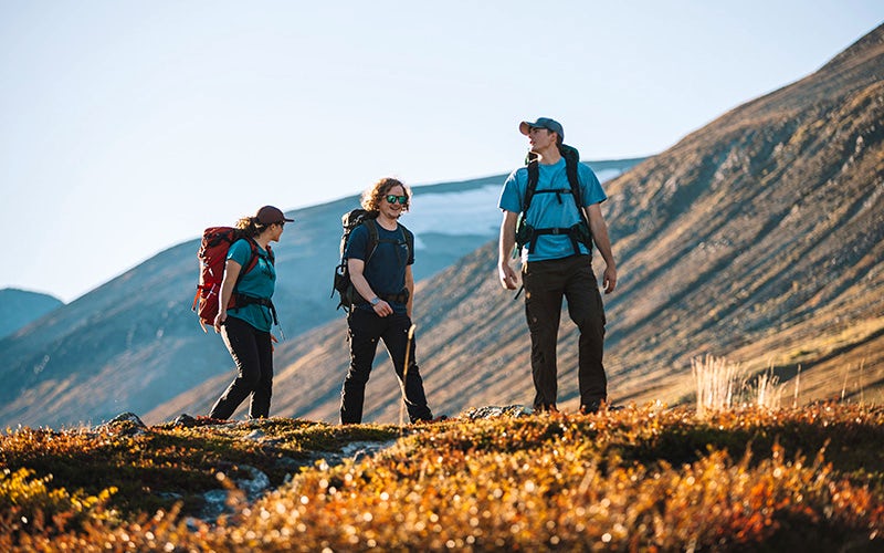 People hiking in autumn landscape.