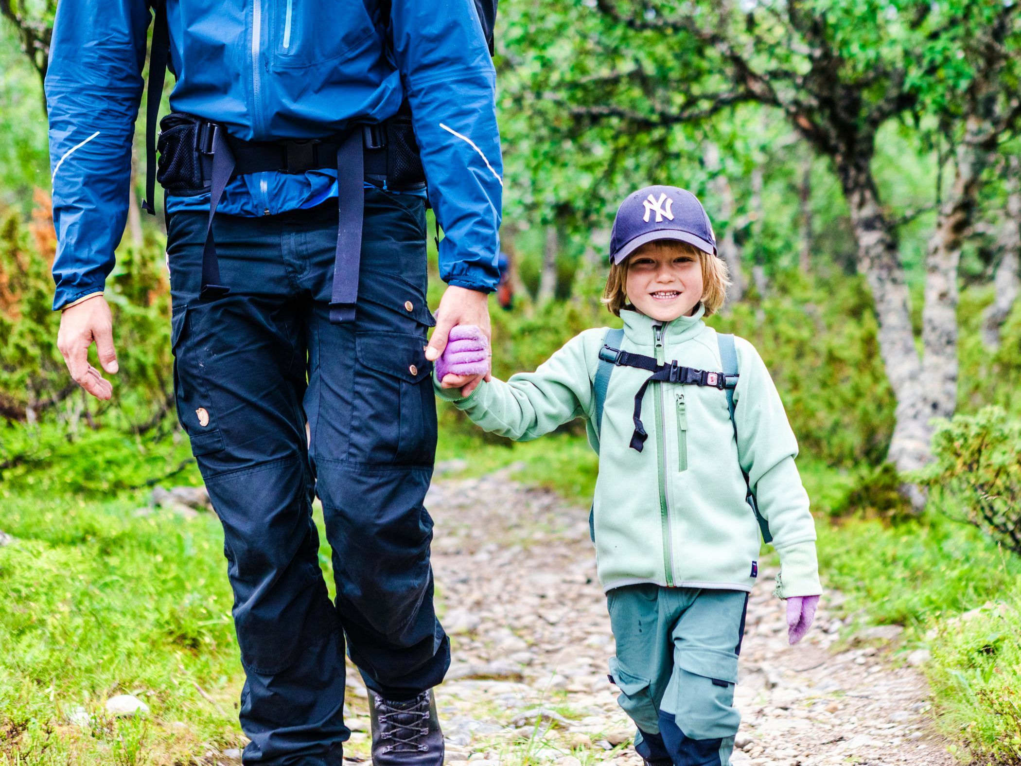 A man and a little girl walking down a trail.