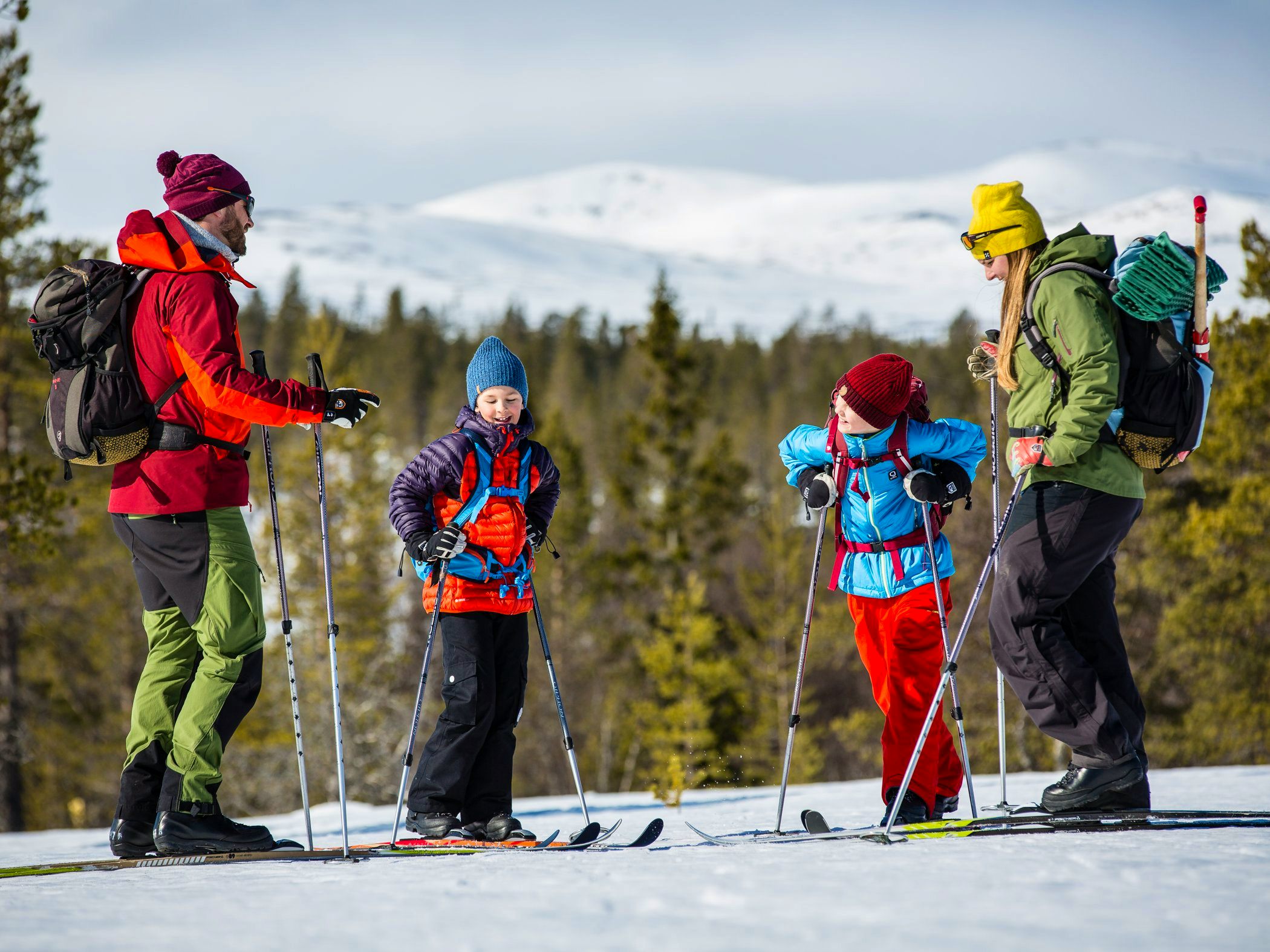 A group of people riding skis on top of a snow covered slope.