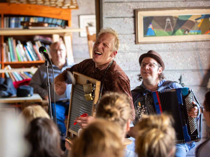 STF Saltoluokta Fjällstation tre personer spelar dragspel.