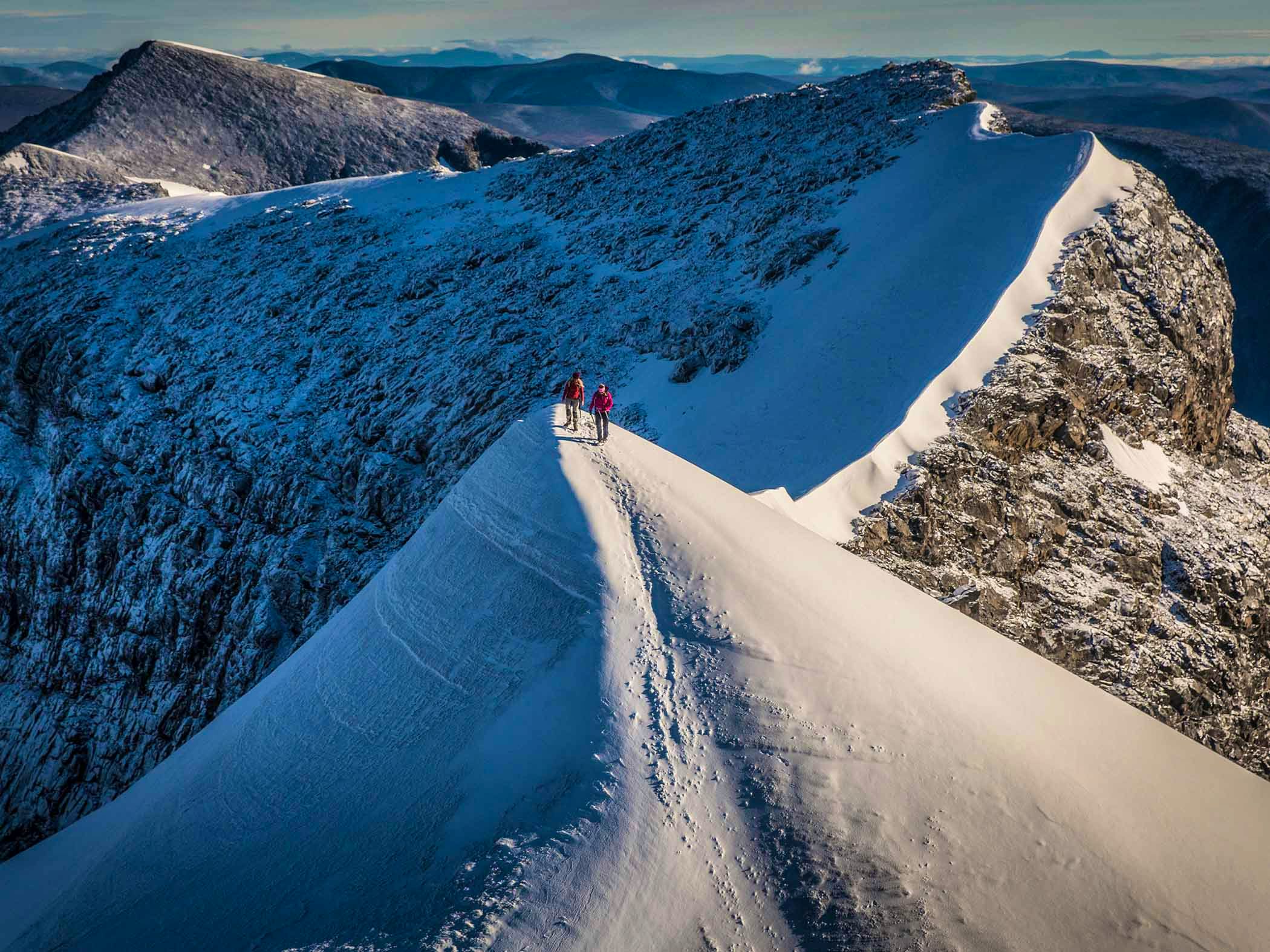 Two persons on the top of the mountain Kebnekaise. 