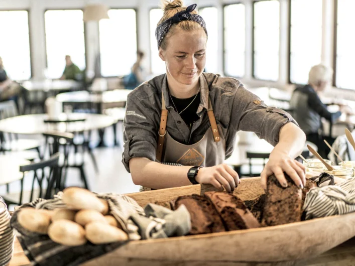 A woman working in a bakery making bread.