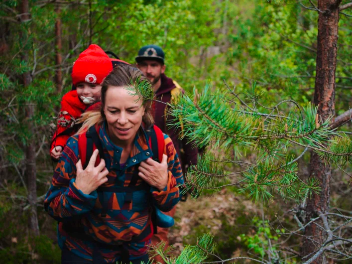 Two adults with a child hiking on Signature trail southern Tjustleden.