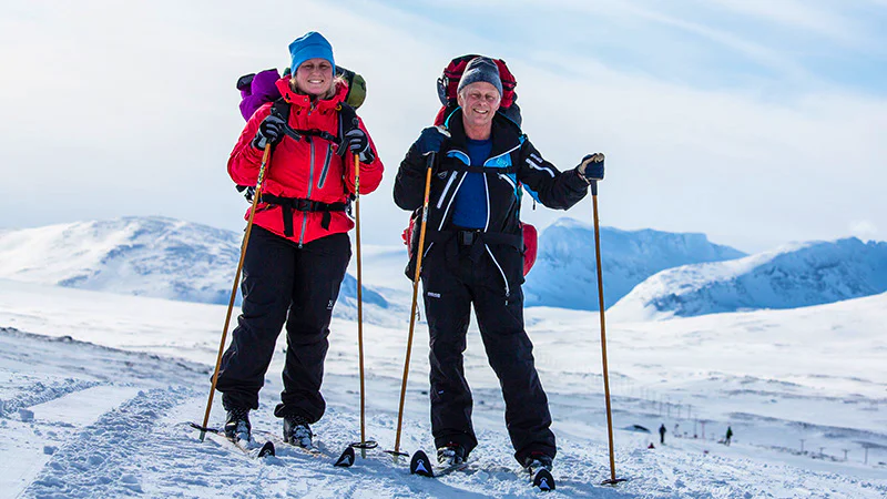 Cross-country skiers in the snowy mountains.