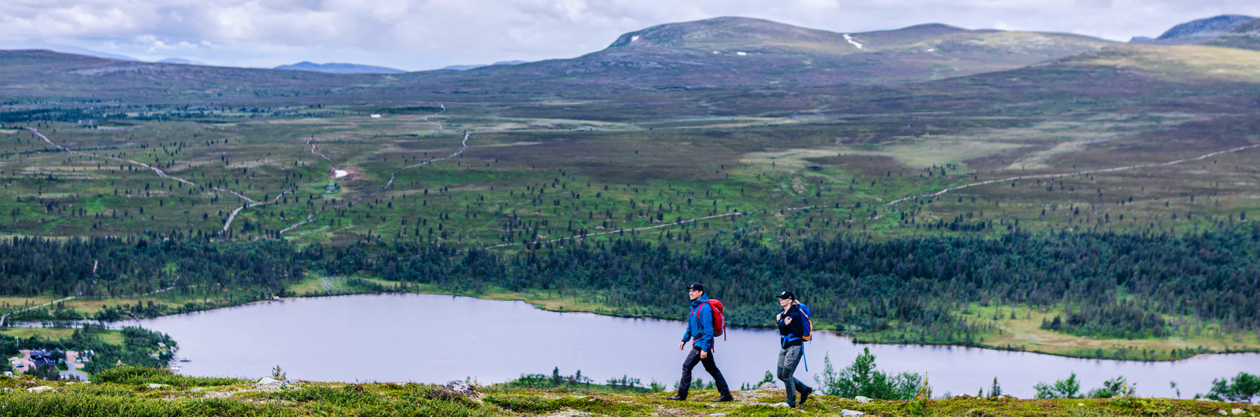 Two people hiking along Grövelsjön.