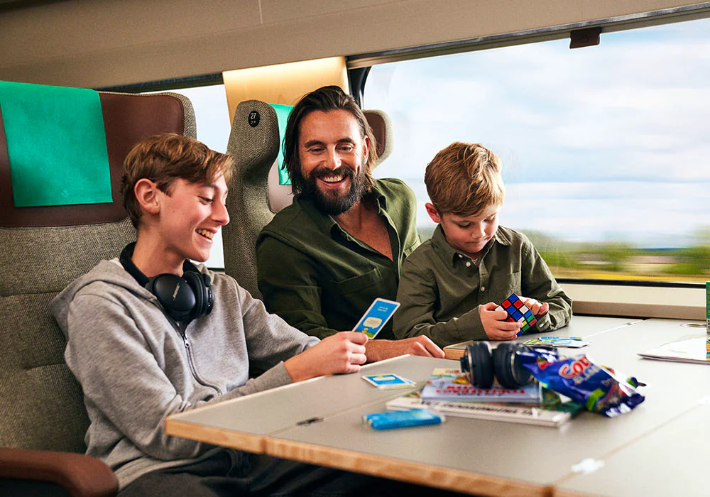 A man and two children riding on a train.
