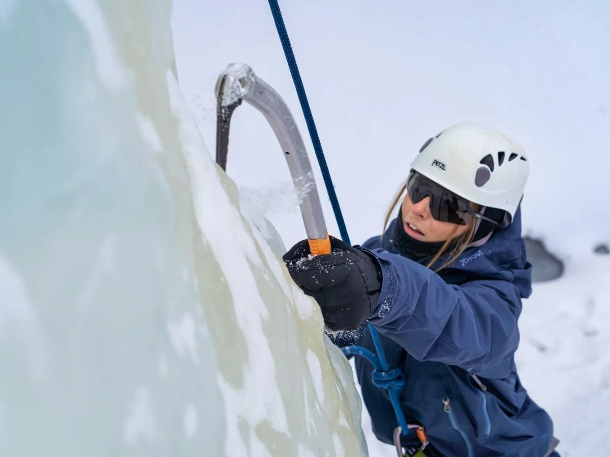 Ice climber ascending a frozen ice wall.