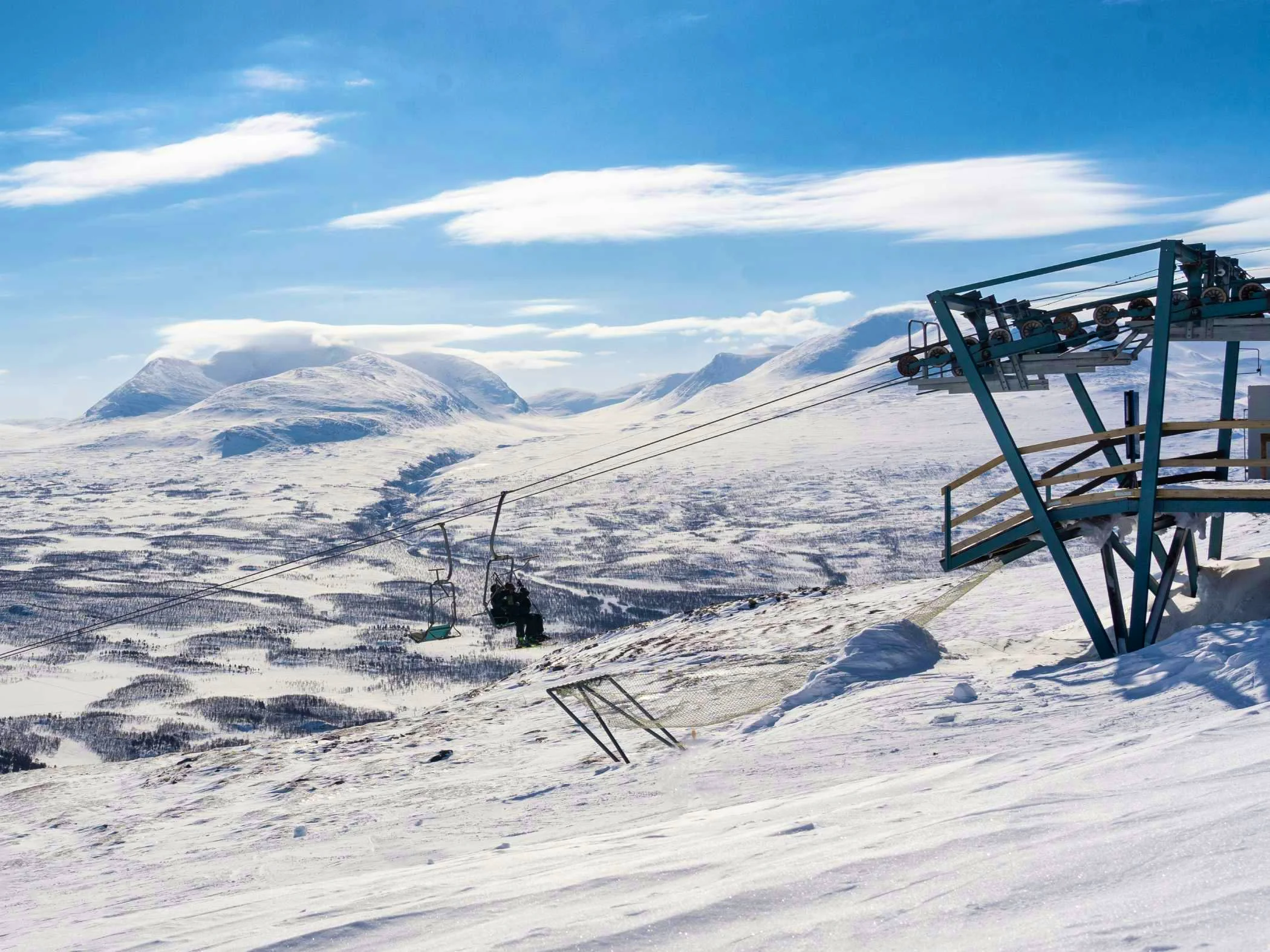 Snow-covered mountains with a chairlift.